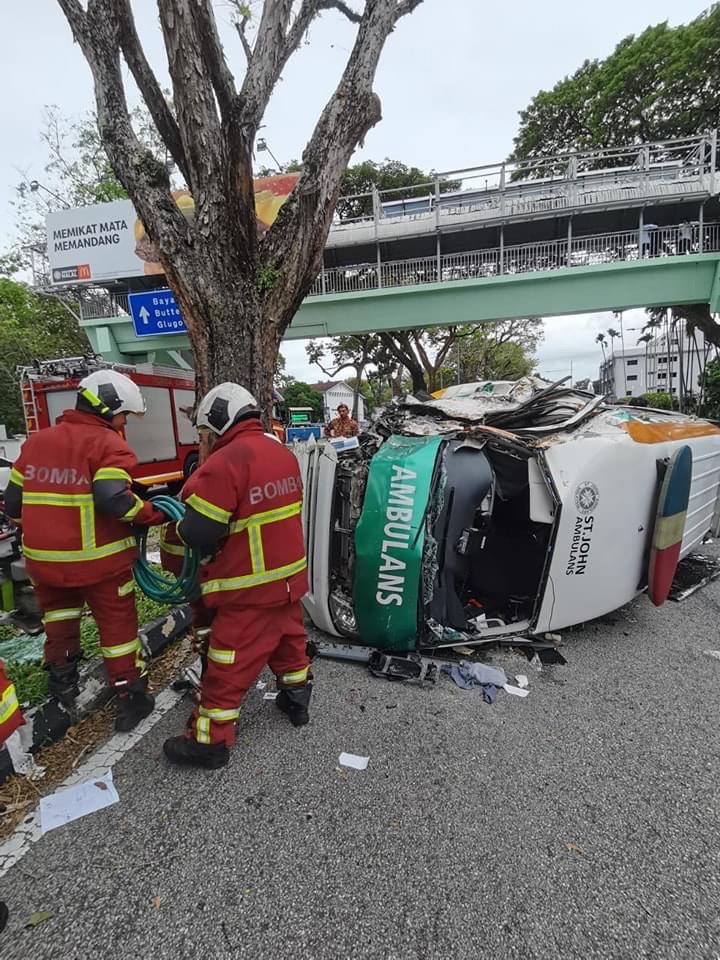 St john ambulance carrying patient inside flips over after slamming into a divider