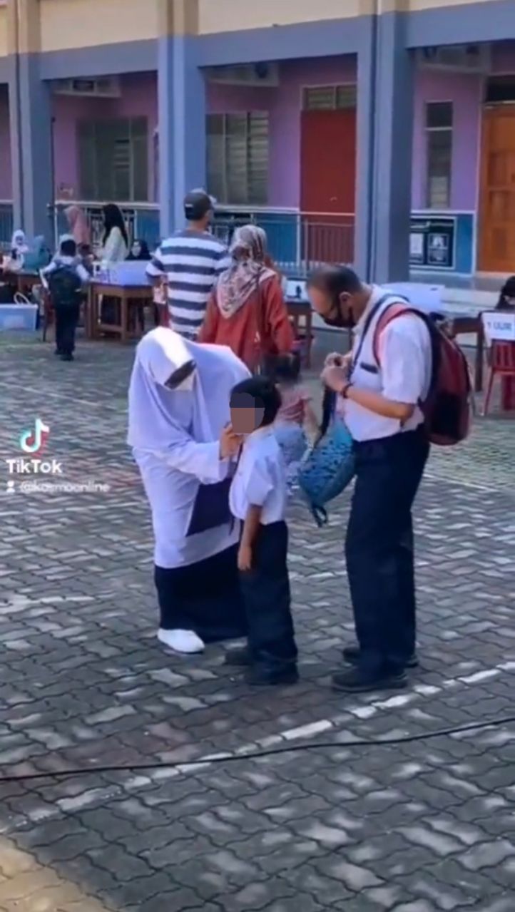 Supportive m'sian parents wear school uniforms to encourage son on his first day at school
