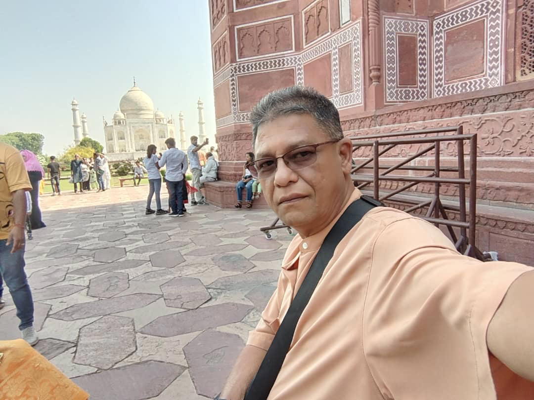 Msian man takes a selfie with taj mahal at delhi, india