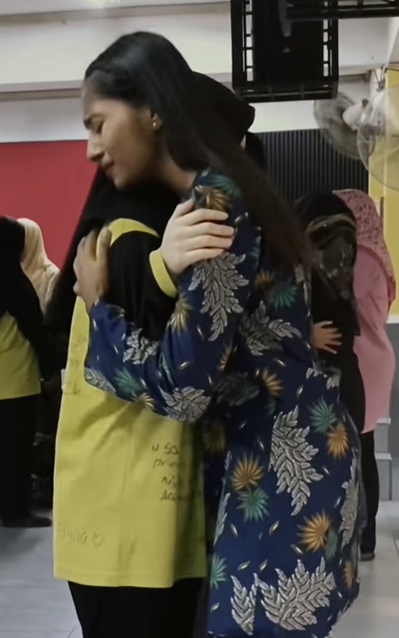 Teacher hugging her student tightly, while both are in tears
