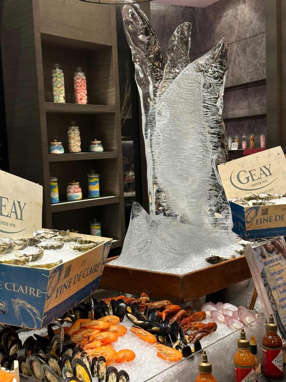 Carved ice on display with different types of raw fishes and seafood