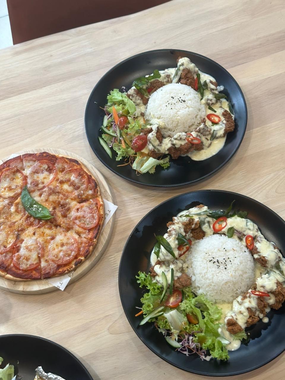 Buttermilk chicken rice and pizza served on a table
