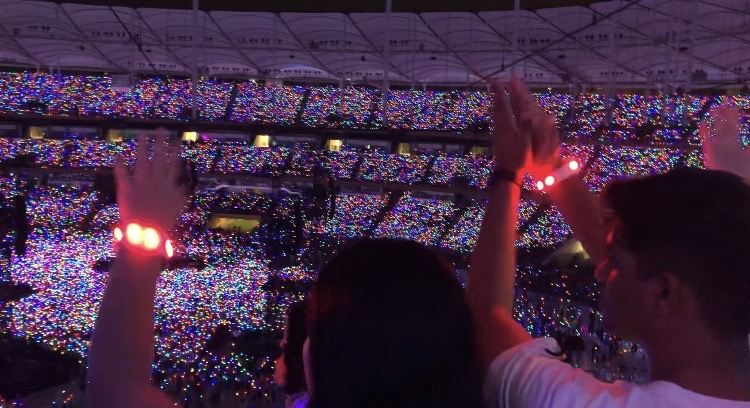 Fans cheering and clapping at coldplay concert
