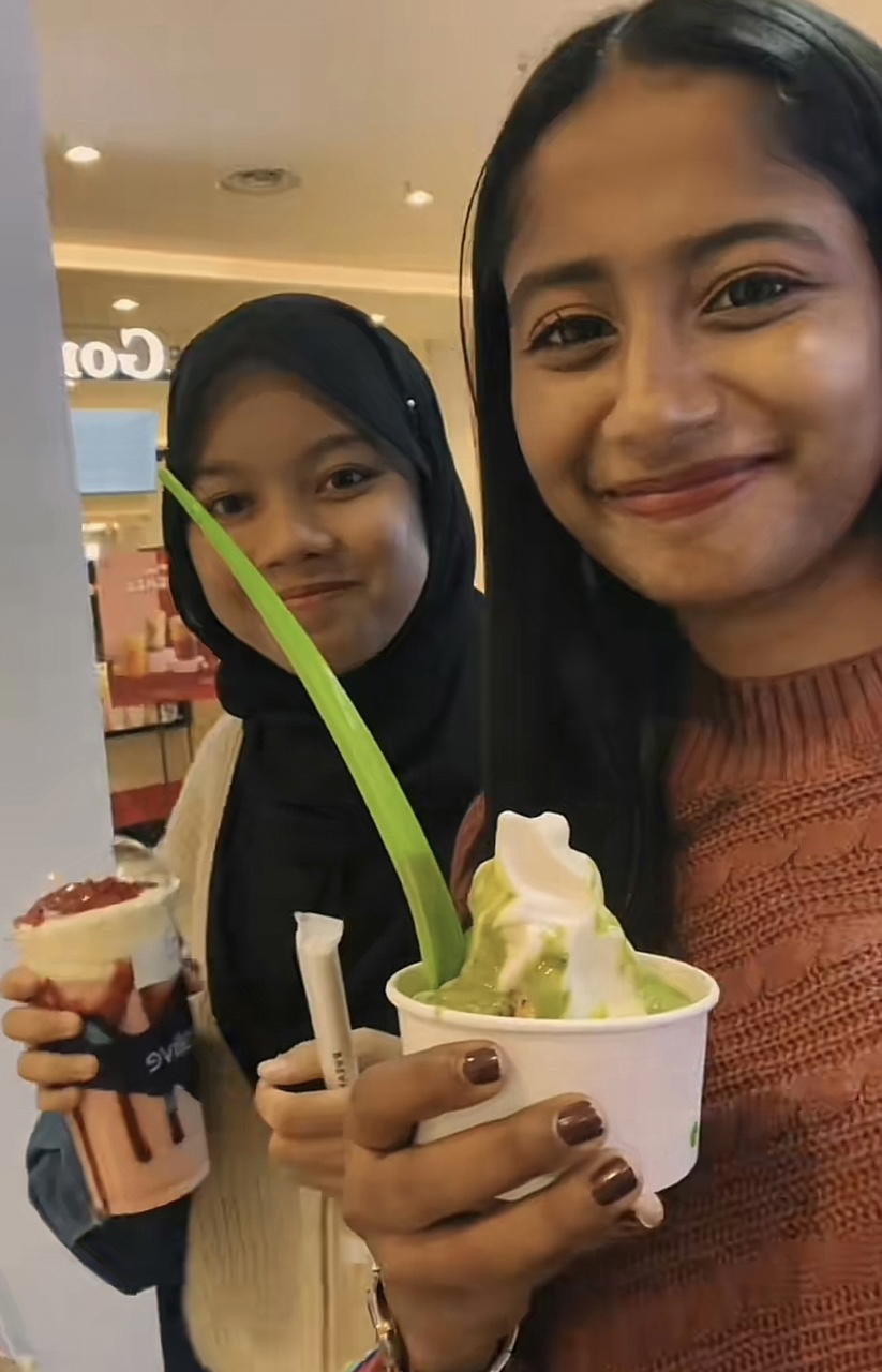 Teacher having yoghurt while her student has a drink