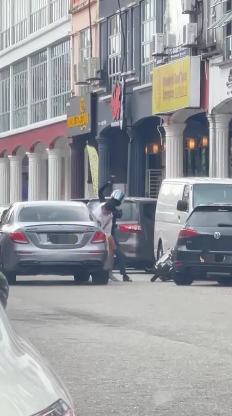 M'sian man and officer fighting each other by the roadside