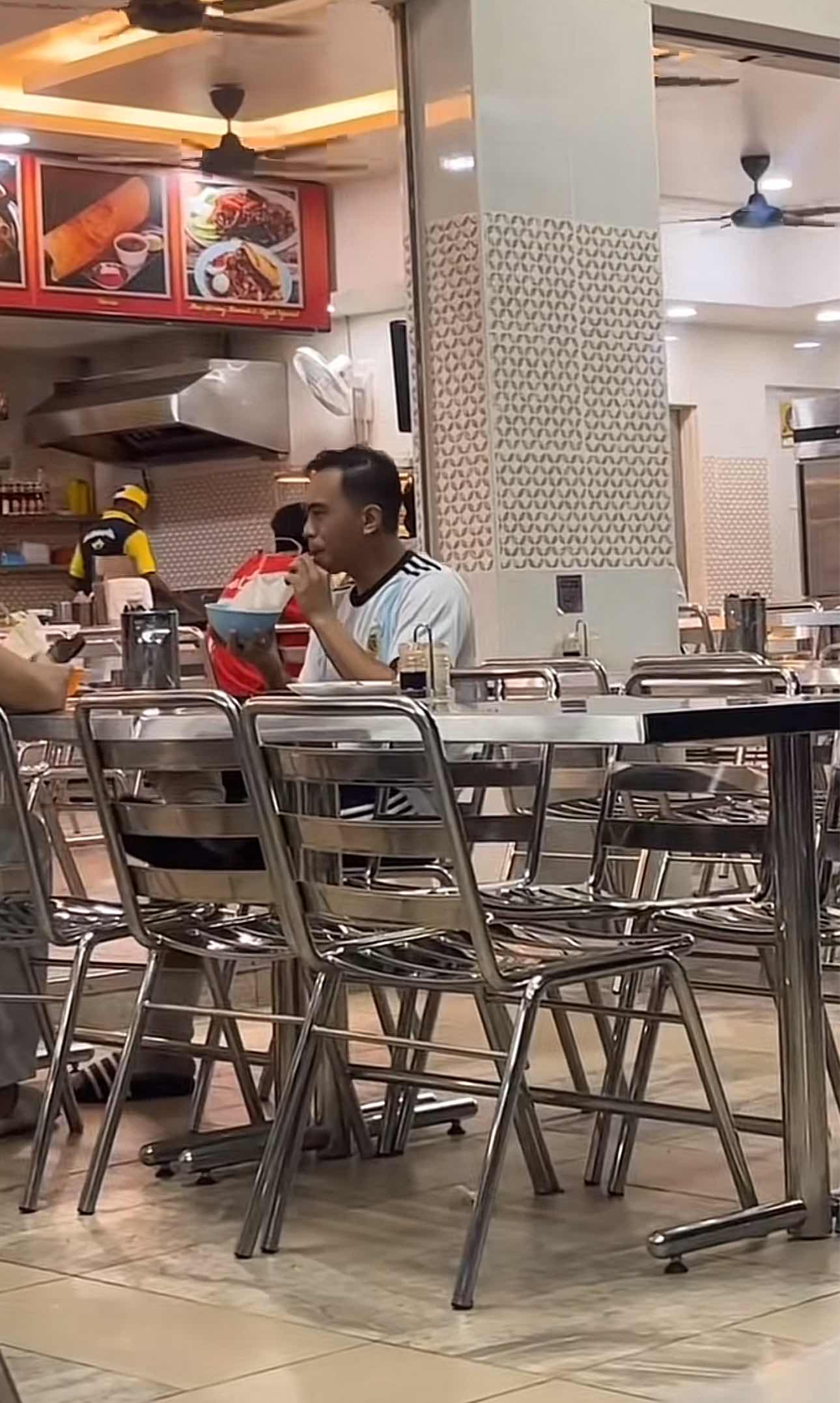 Man sipping his drink at the mamak