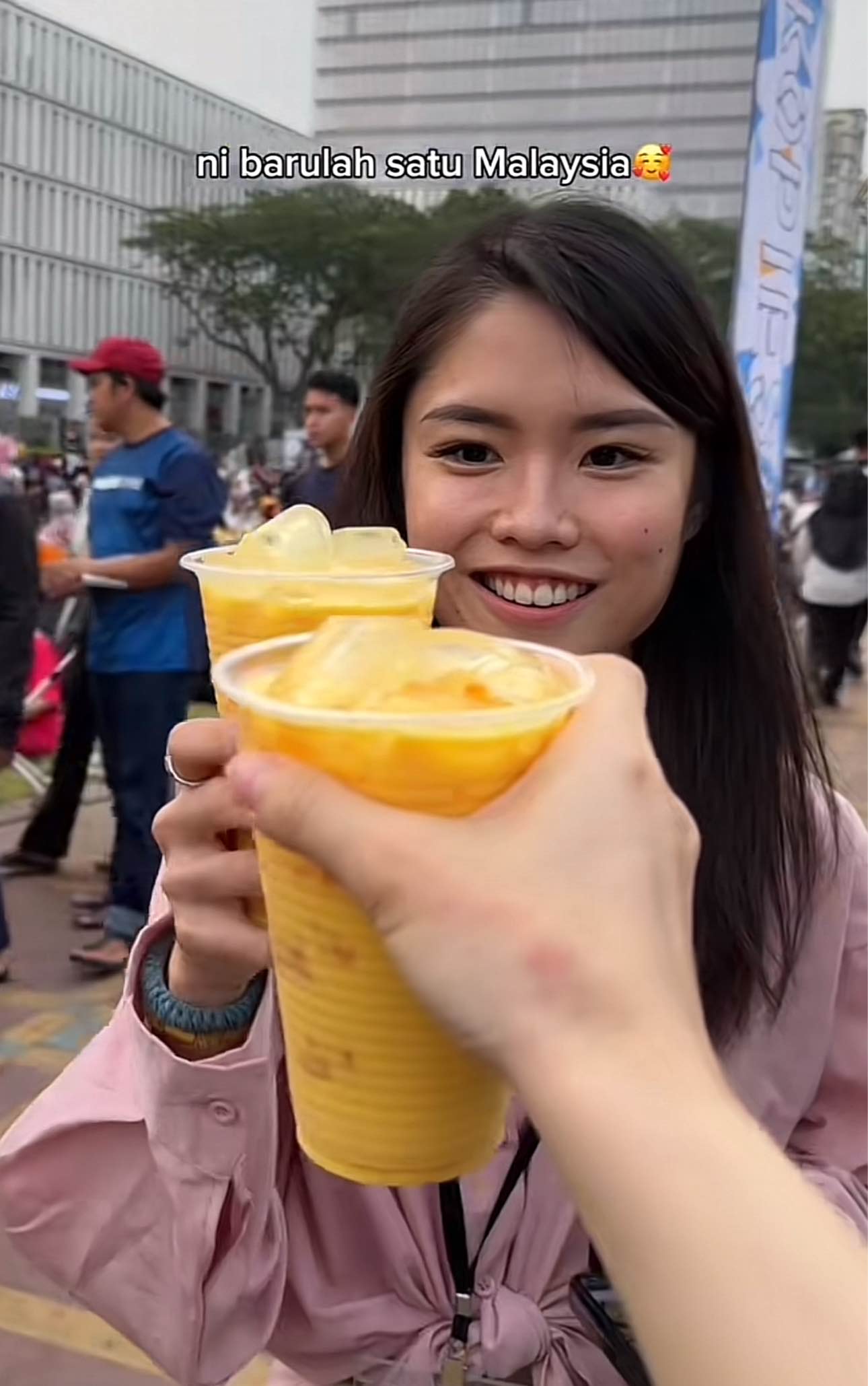 Two chinese woman cheers drinks at putrajaya square