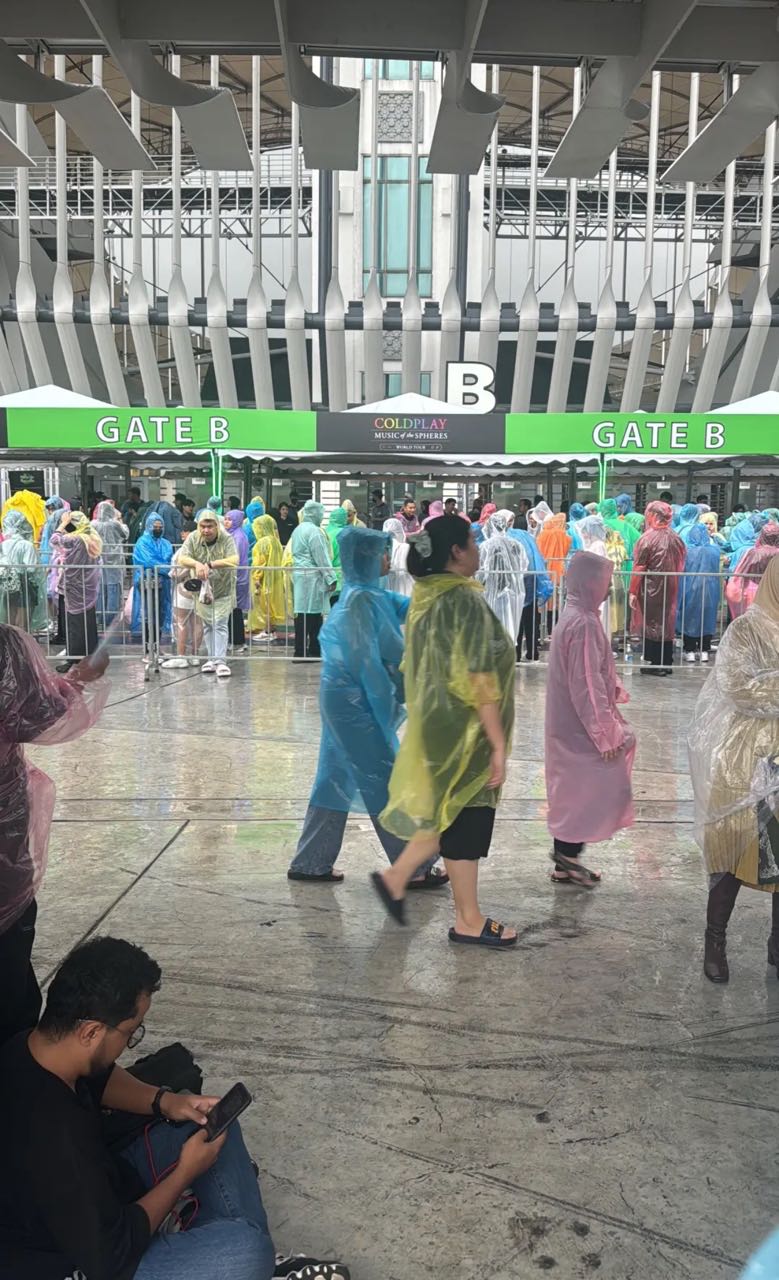 Coldplay fans lining up to enter his concert under the rain
