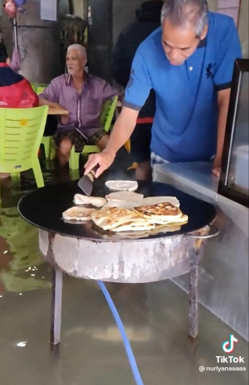 Roti canai vendor operates business as usual despite flood reaches knee level, amazes netizens