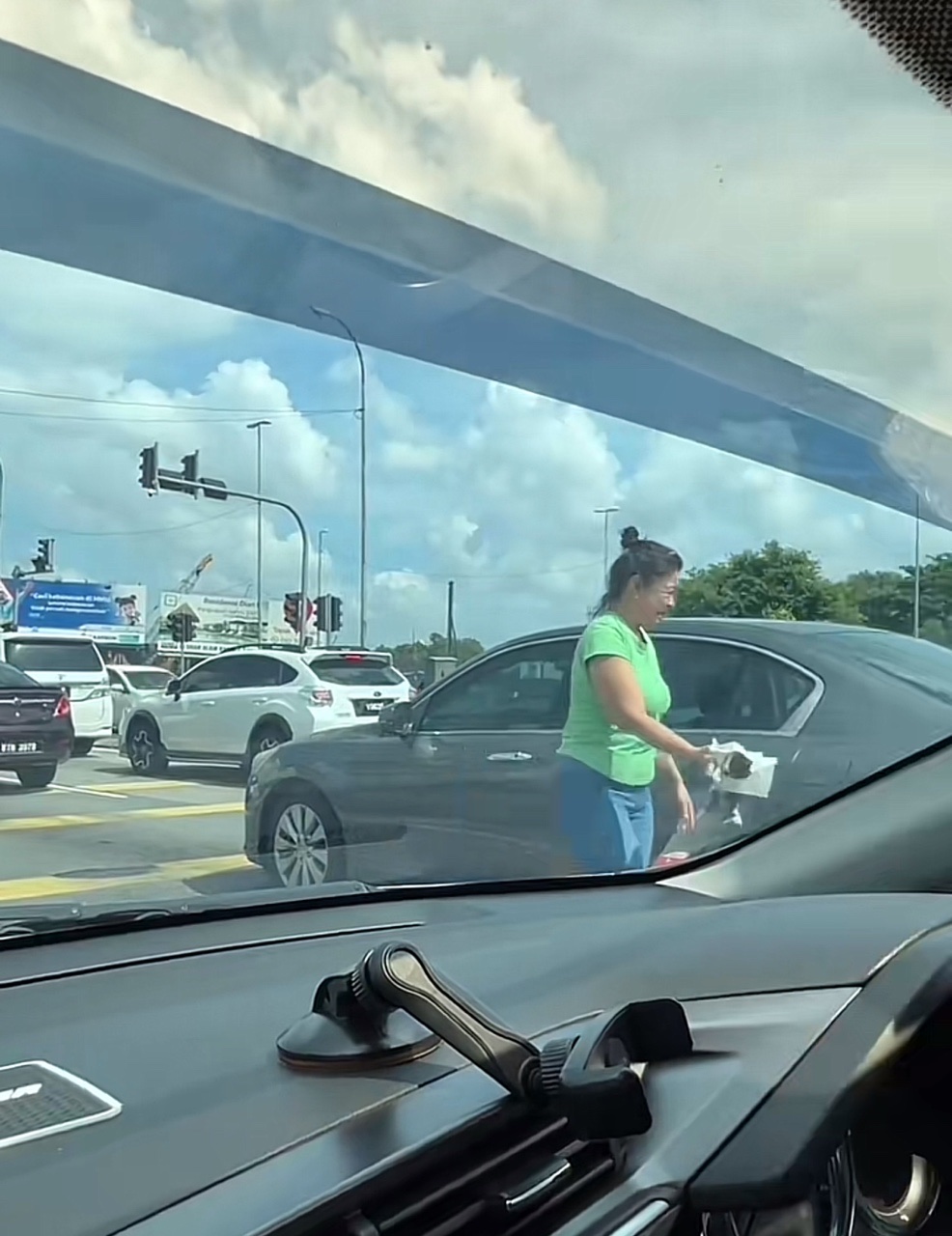 Msian woman bringing the dead cat to her car bonnet