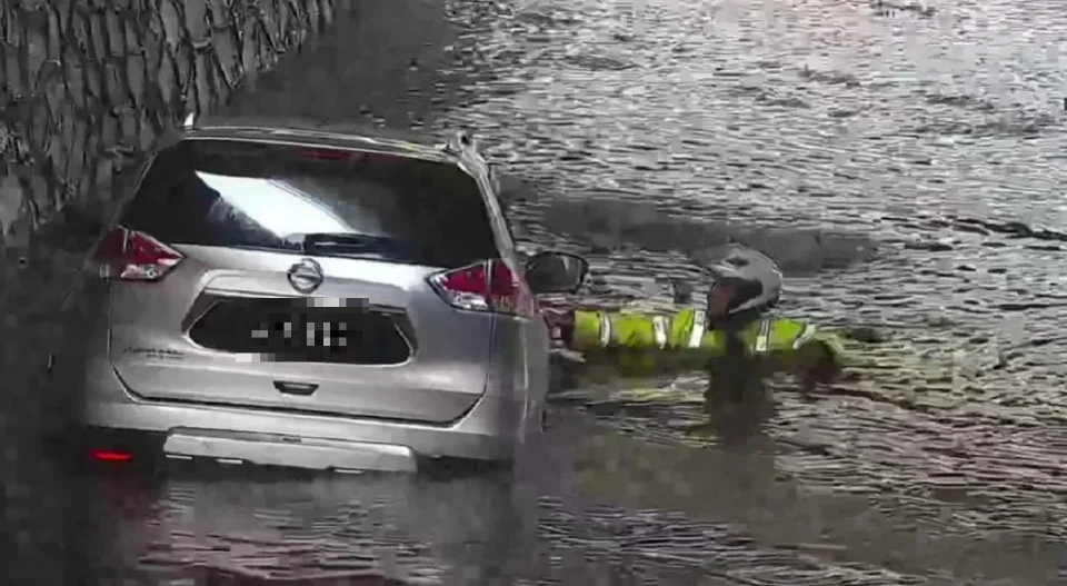 Malaysian traffic police risk his life to rescue driver trapped in flash flood