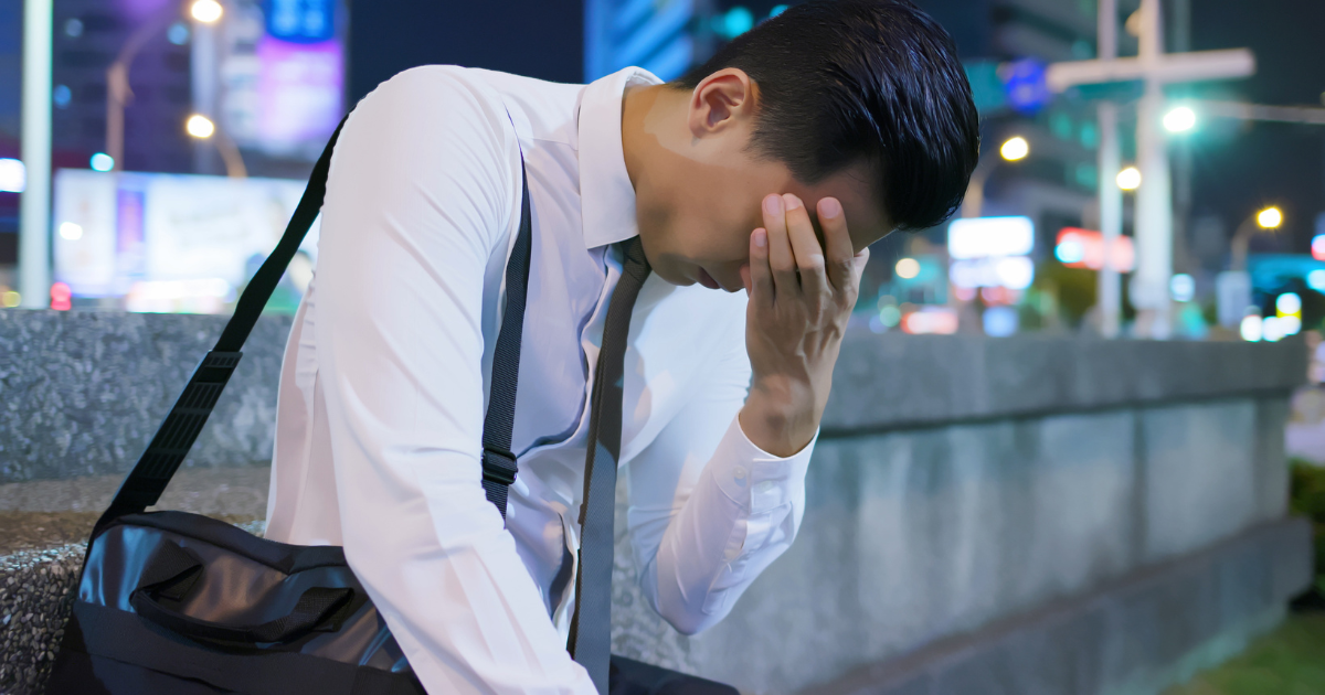 Asian man in work uniform seems stressed