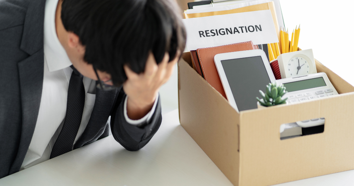 Man in suit has his resignation box next to him