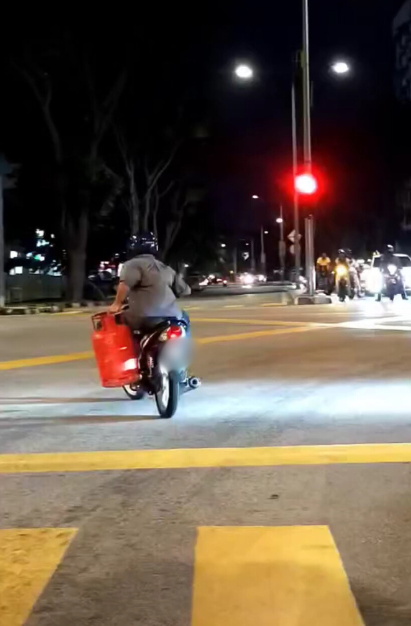 M'sian motorcyclist rides through traffic at night holding gas cylinder with one hand | weirdkaya