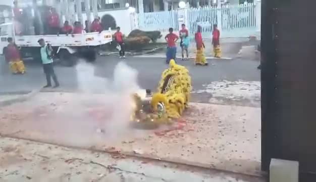 Lion dancers perfroming infront of a house