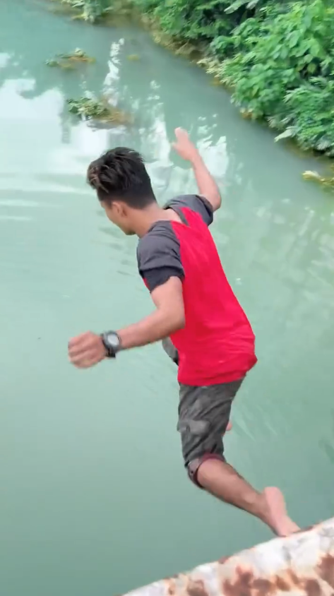 Msian jumping off a bridge into the jade green river at machang, kelantan