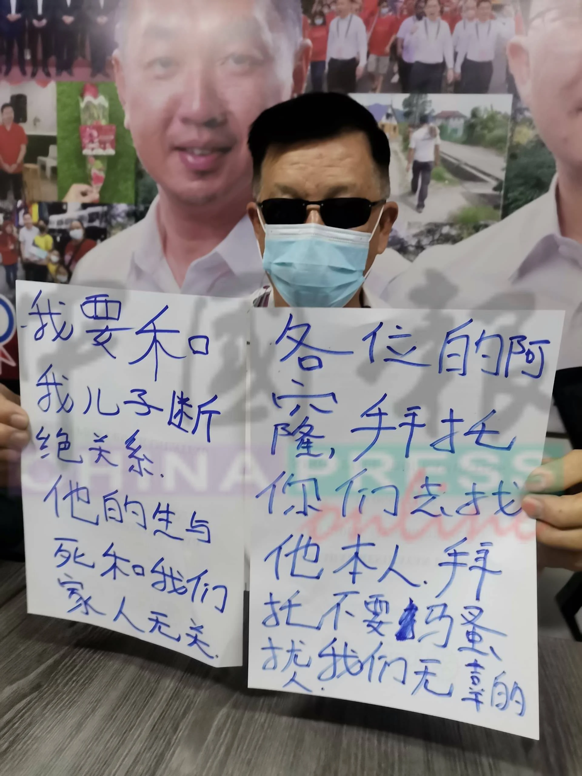 Ma holds sign which announced son's disownment