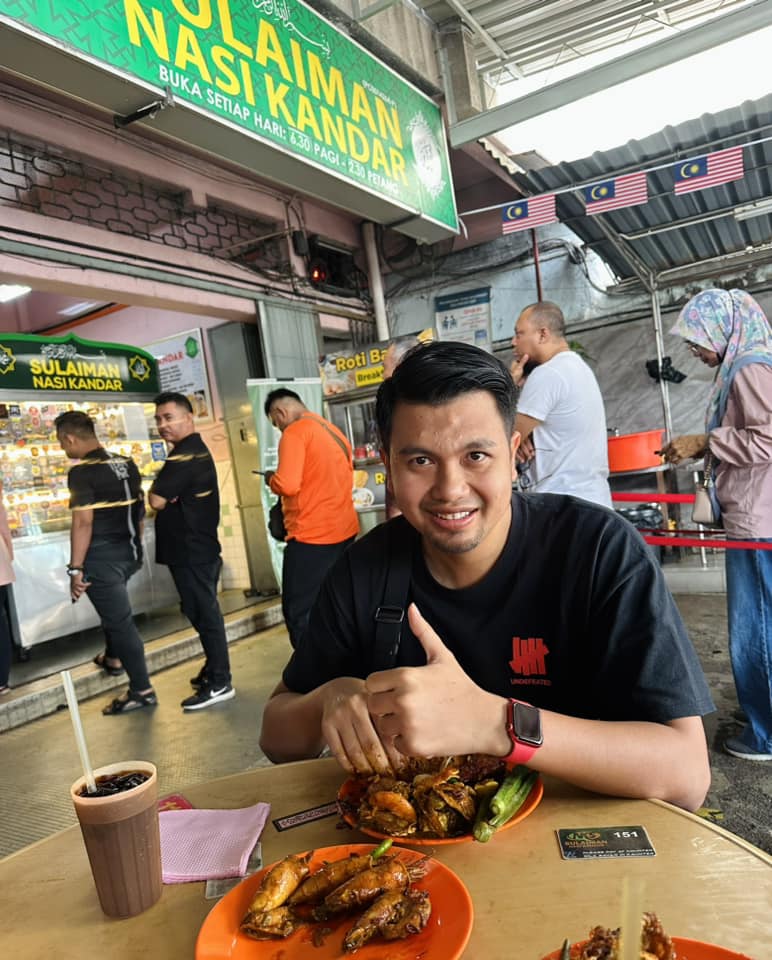 Malaysian man eating nasi kandar at a restaurant