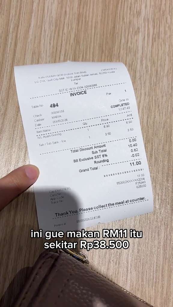Malaysian woman showing a receipt of the meal she purchased