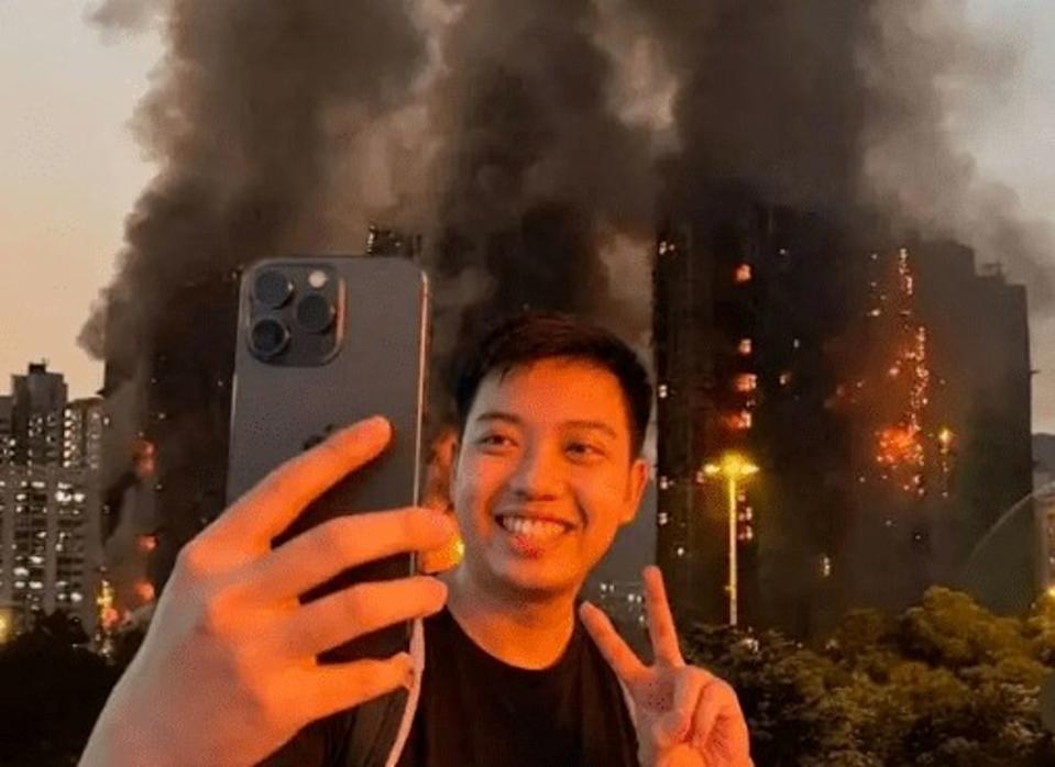 Man from China Grins while posing in front HK Fire