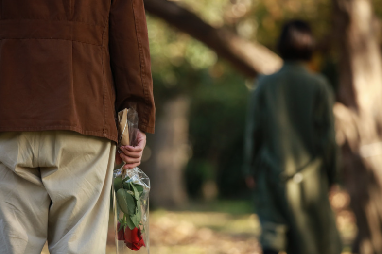 Man holding roses for woman