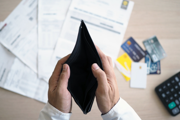 Man looking at empty wallet