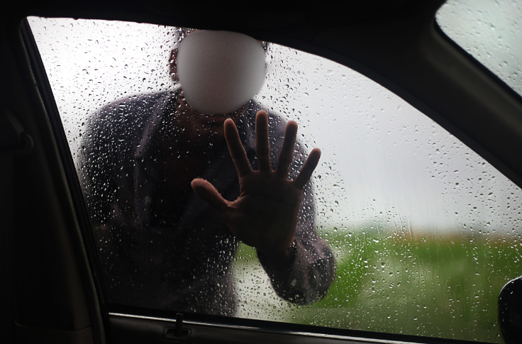 Man placing hand on car window