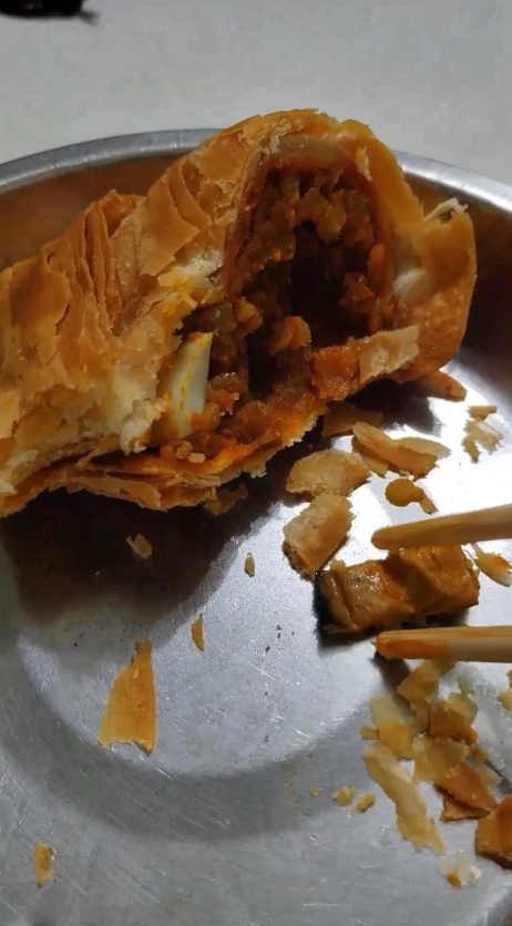 Man showing cigarette butt inside curry puff