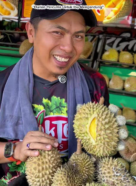 man showing durian at his stall