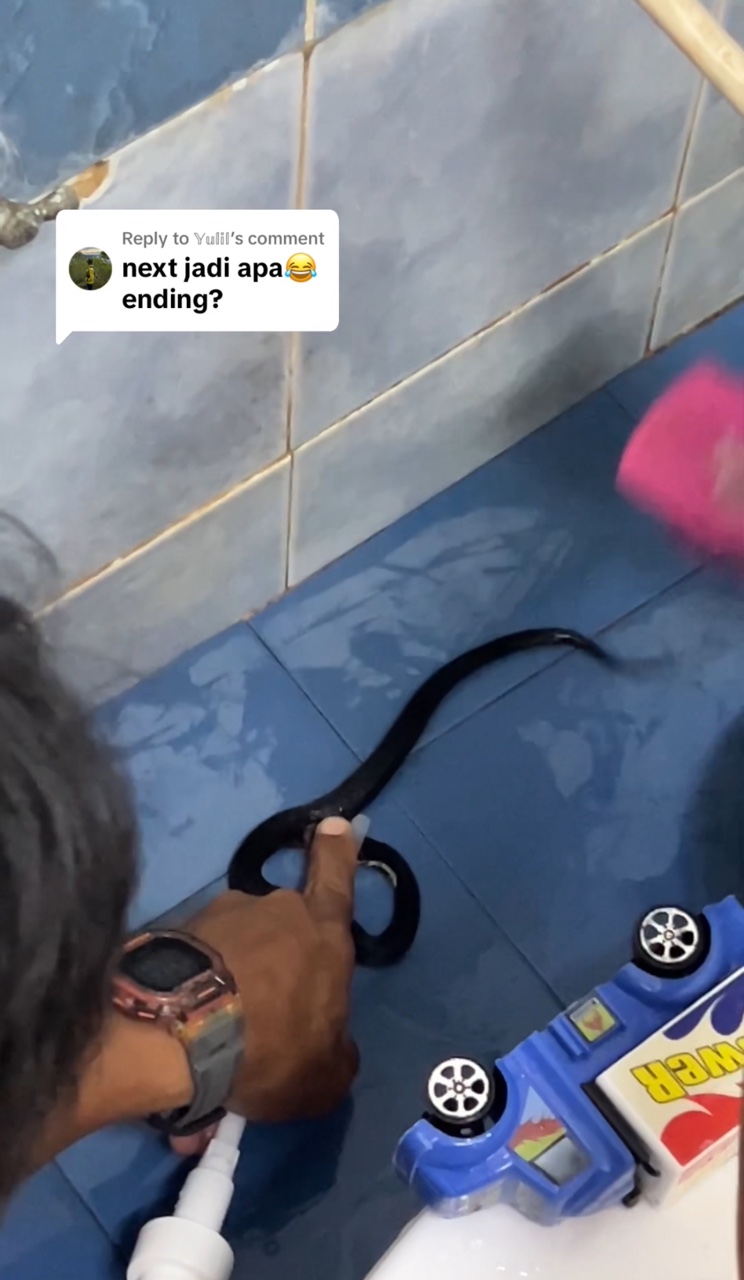 Man using his finger to stop a snake from escaping