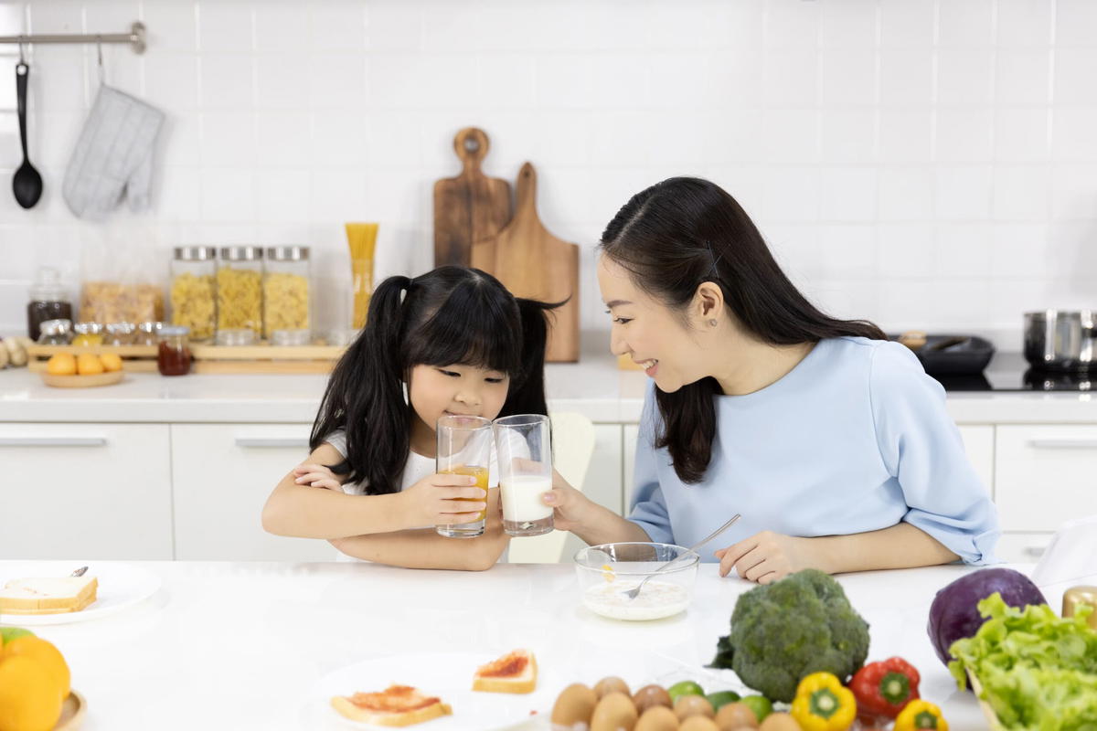 Asian mum drinking milk with her daughter.