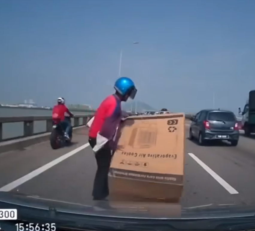 Motorcyclist helping to remove box