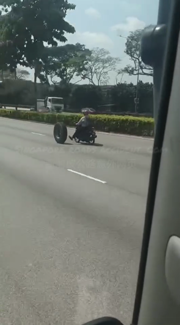 Motorcyclist kicks car tyre