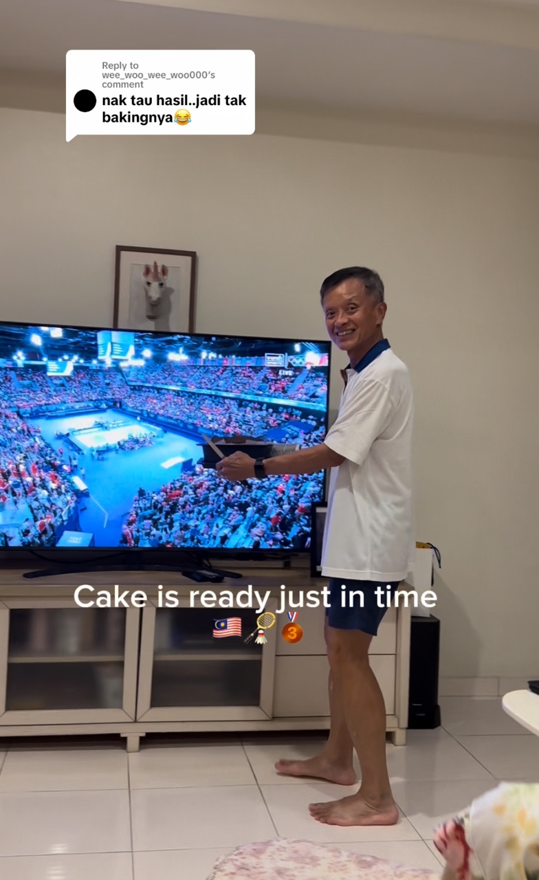 Msian dad showing the cake infront of the tv