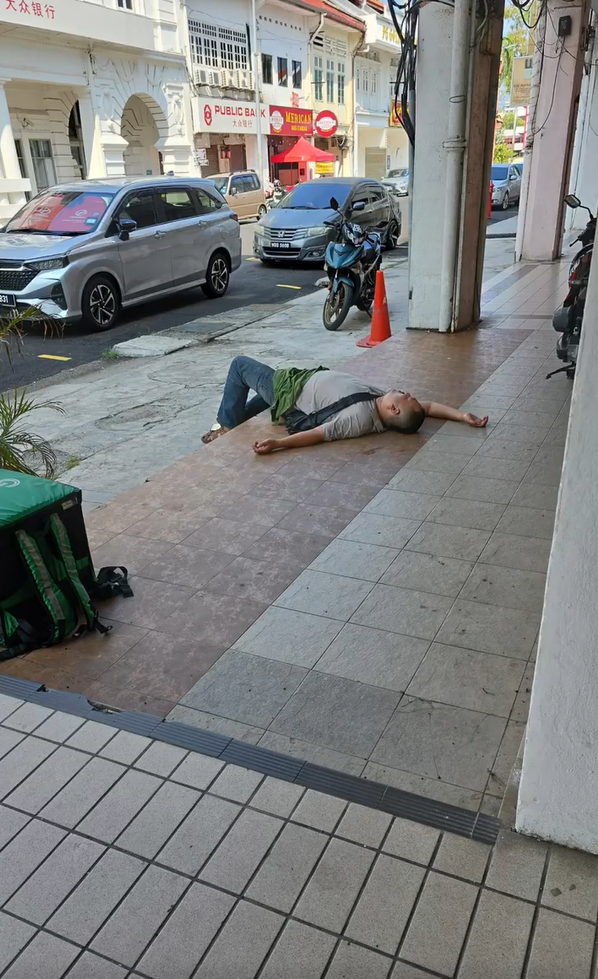 M'sian delivery rider falls asleep along five-foot walkway