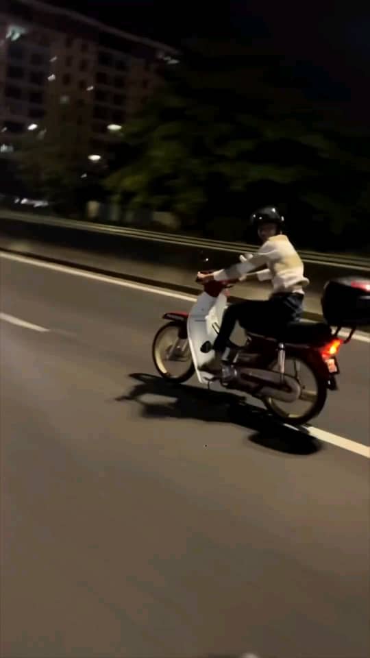 Msian man riding motorcycle on road at night
