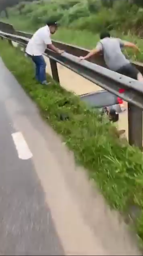 Msian man swiftly jumps into the drain to rescue a woman