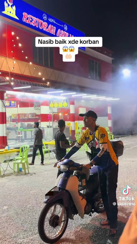 Msian moving his motorbike from the fire incident place