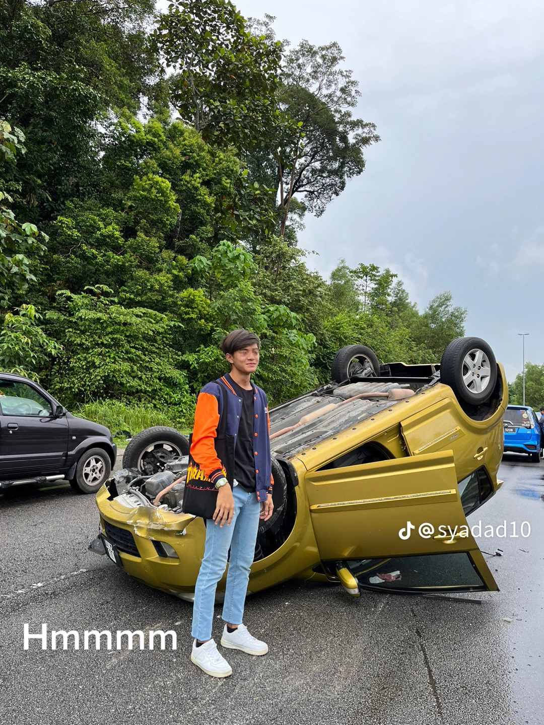 M'sian myvi driver poses with his car after crawling out from it in an accident 01