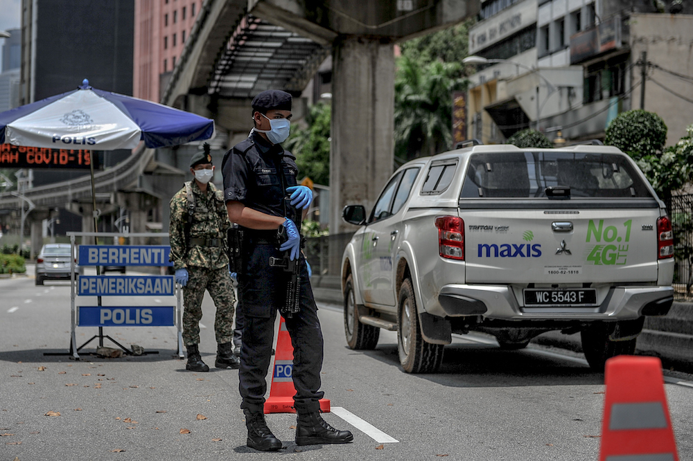 M'sian police guarding roadblock during mco