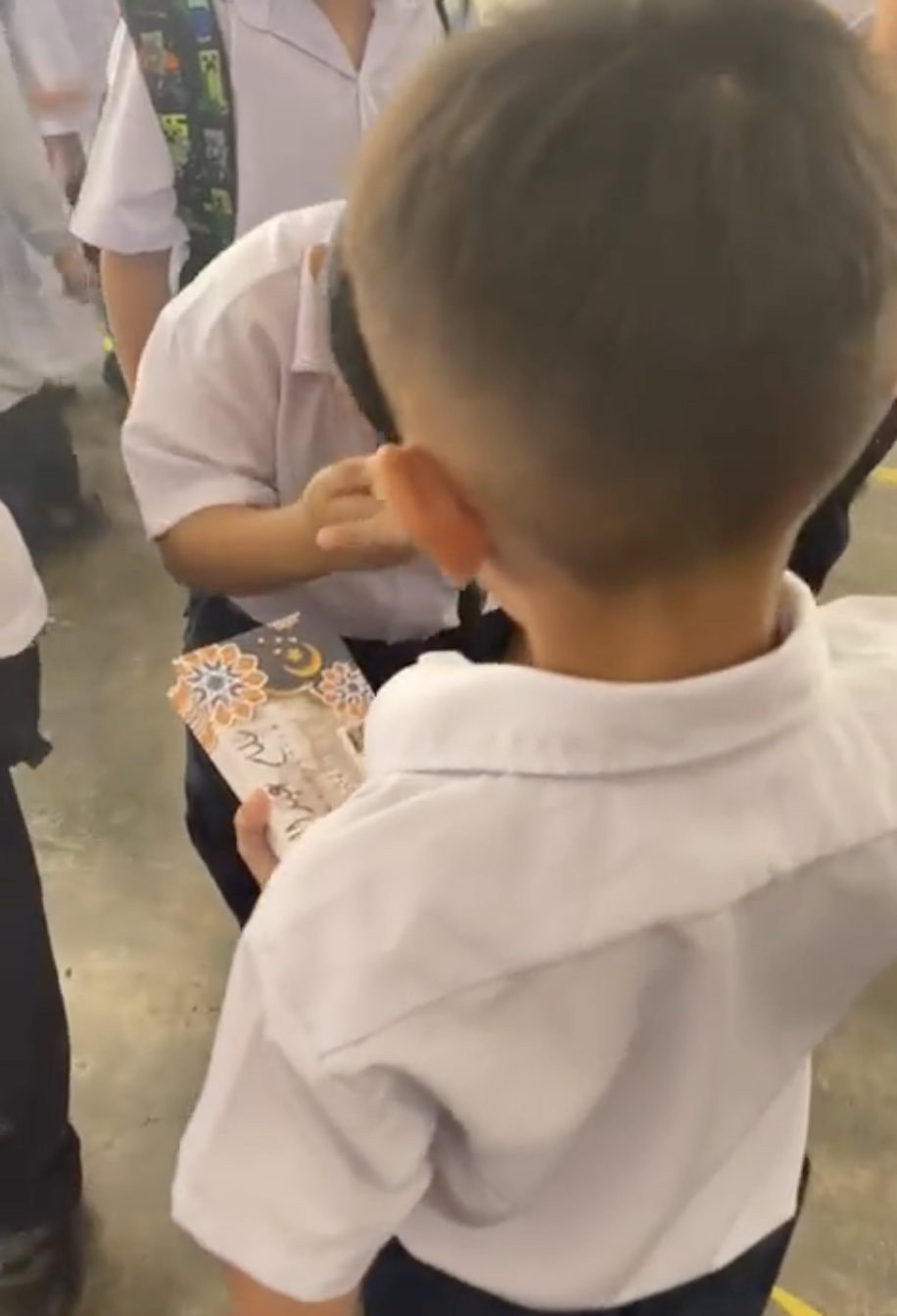 M'sian primary school boy gives out 'duit raya' to his classmates 2