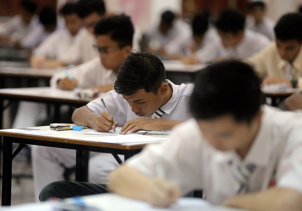 M'sian student writing on his exam paper