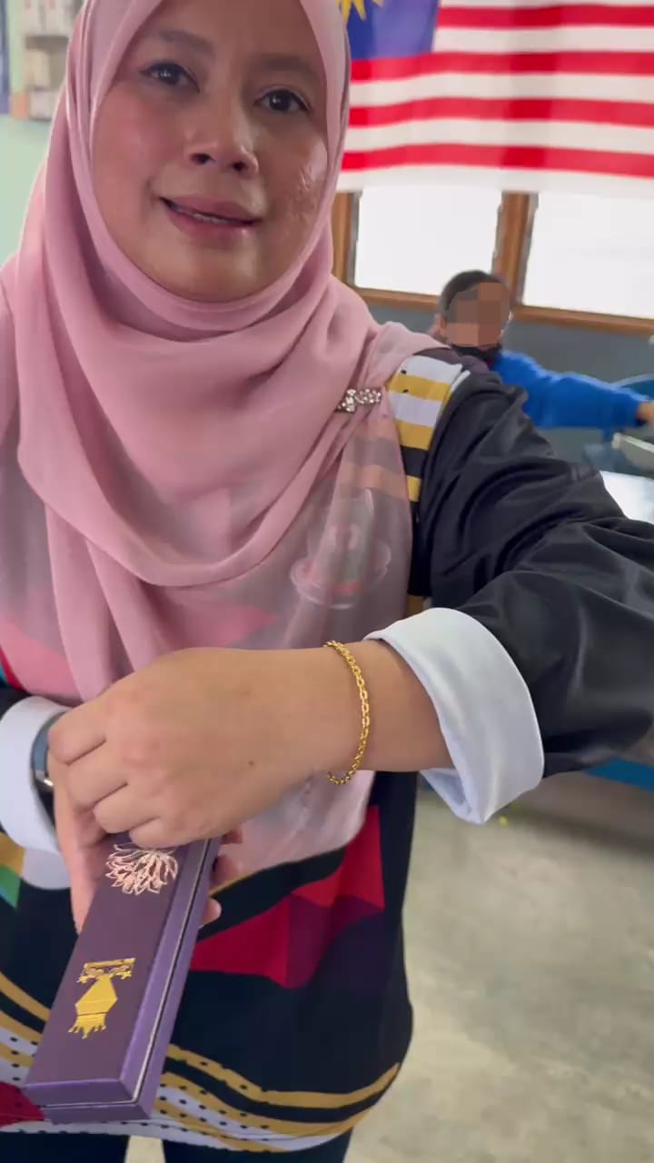 Msian teacher showing the bracelet gifted by her students
