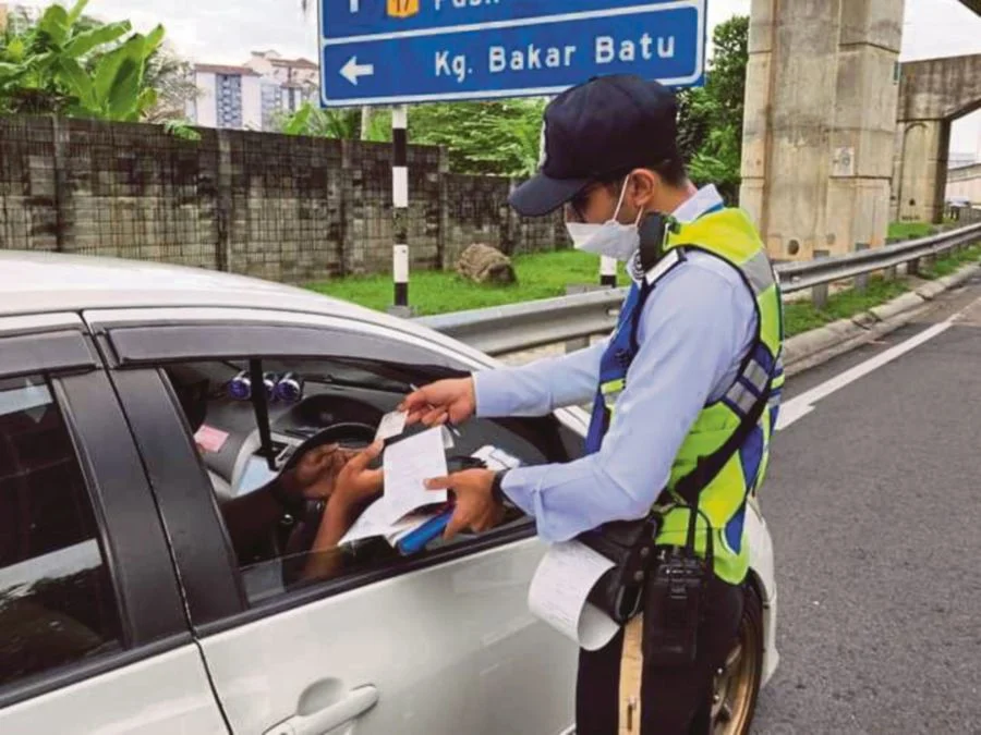 M'sian traffic police handing fine to a driver