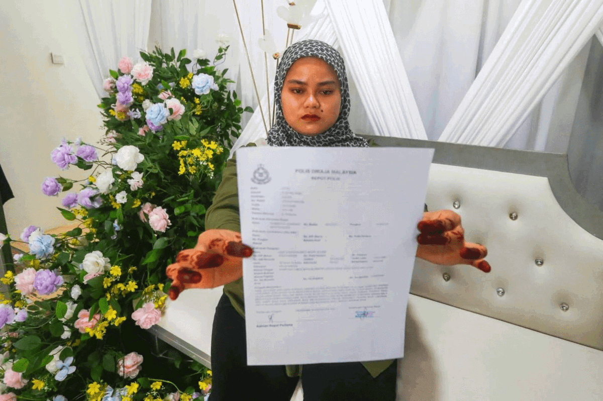 Nor Syafiqah holding police report