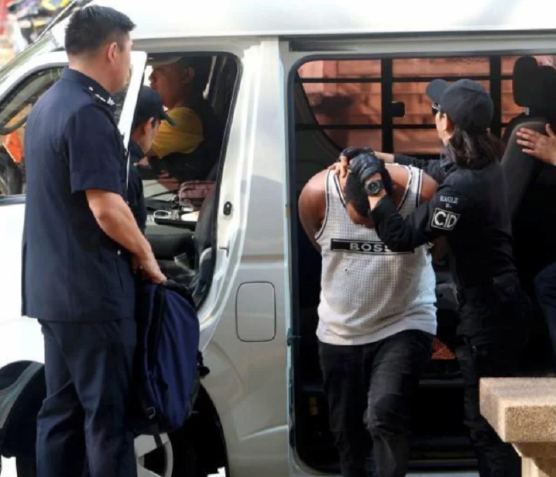 Obianke emerges from police van