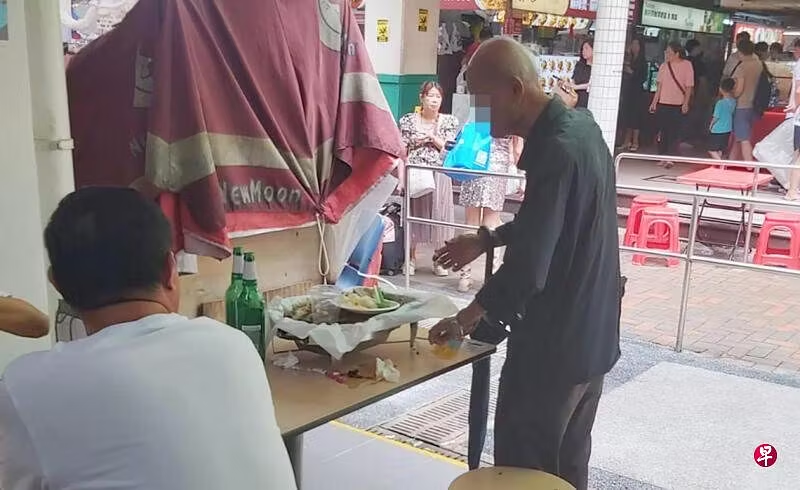 Old man in sg eating leftovers at food court