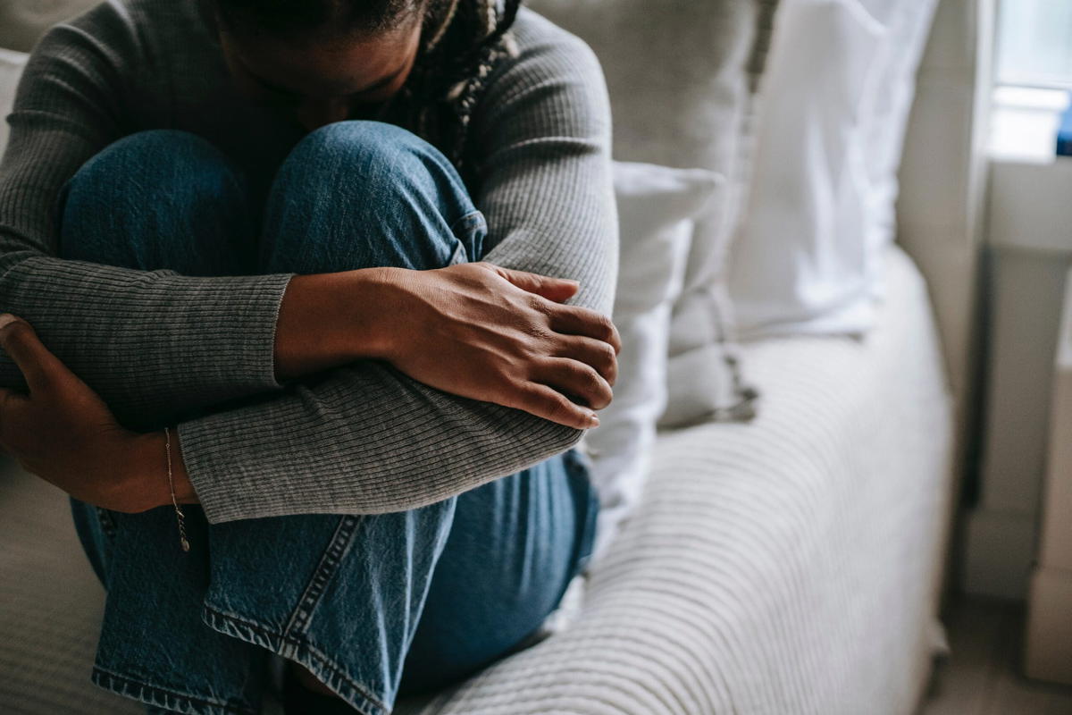 Woman covering her face with her knees