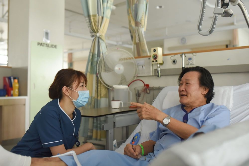 Asian nurse listening to the patient's story in a hospital.