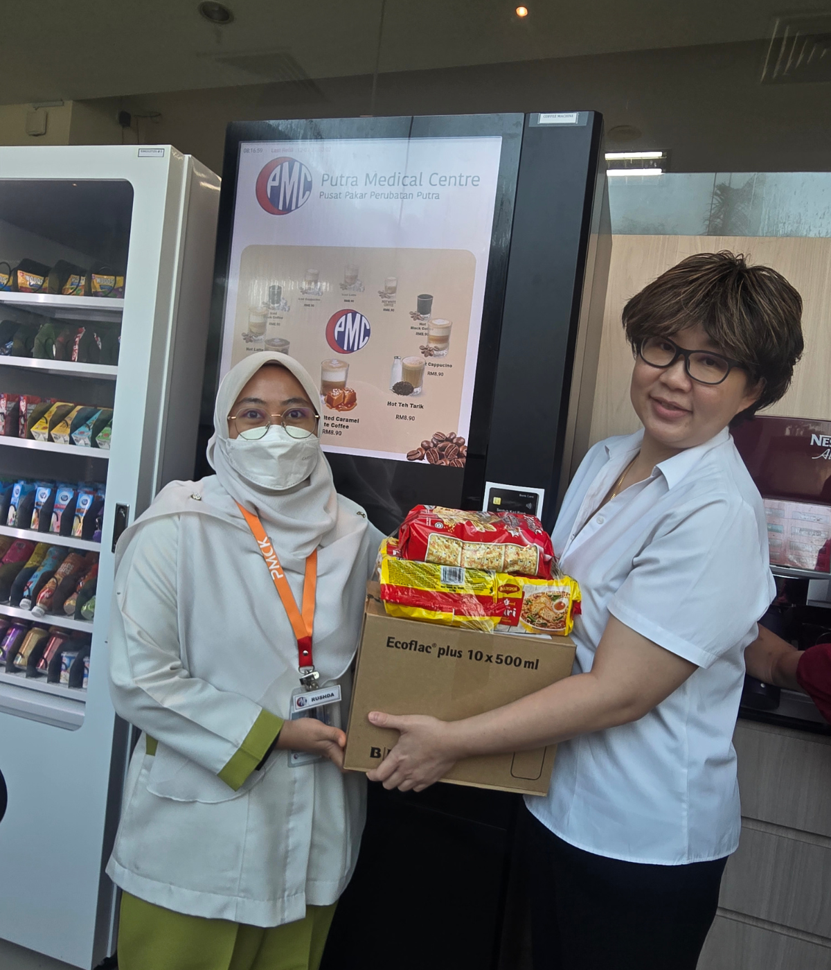 Photo 2 - PMC's Director of Allied Health Services, Lee Geik Peng, offers a care package to a nurse at the hospital affected by Kedah's flood crisis.)